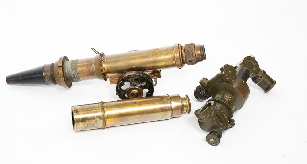 THREE BRASS PIECES.: 20th Century. A telescope, six sections, missing largest section and lens. 34.75"l. Open. An American WWII panoramic tank sight. 9.5"h. And a transit, 17.5"l.