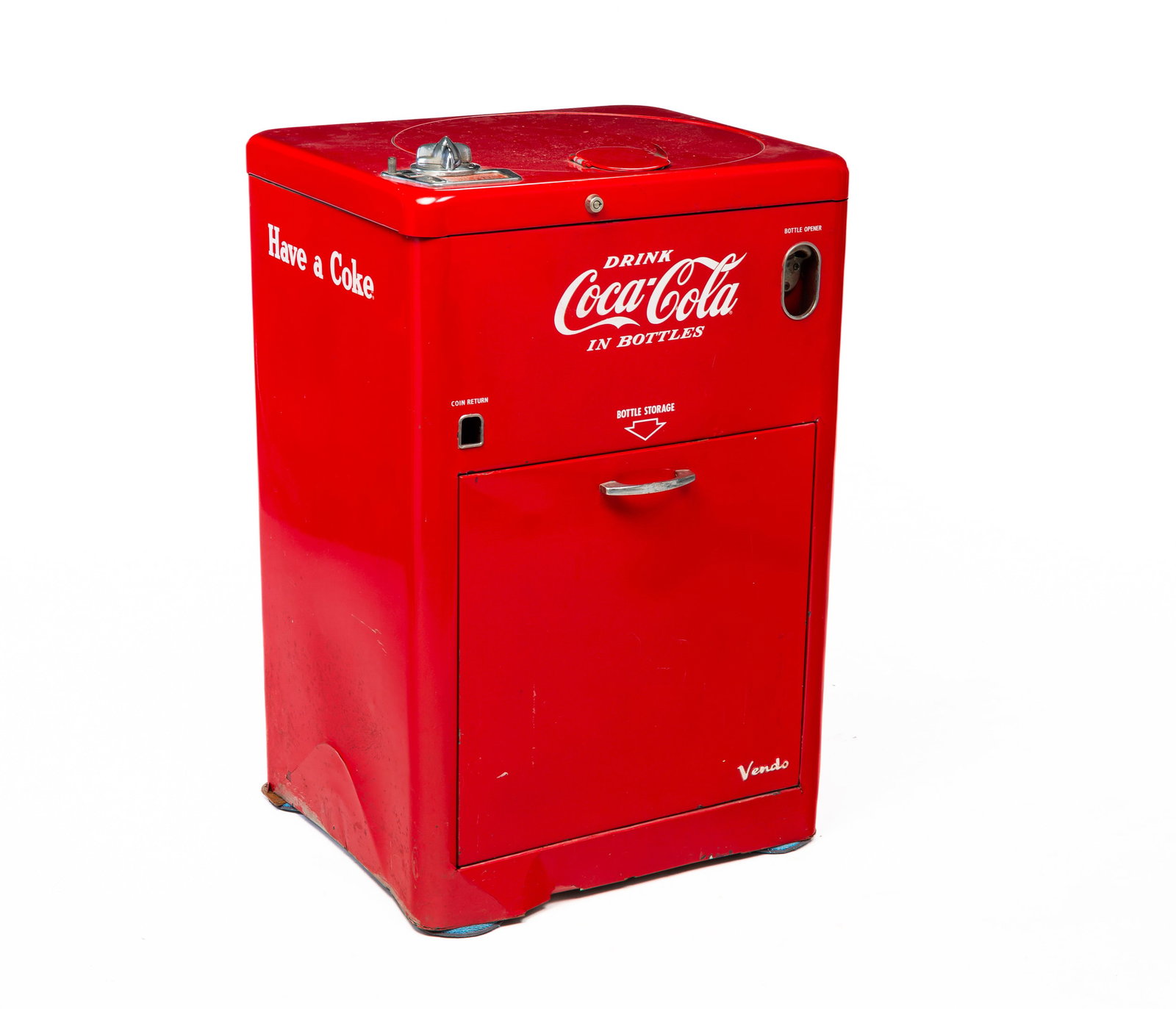 VENDO COKE VENDING MACHINE.: American, mid-20th Century. Low cooler with revolving top and empty bottle storage drawer in bottom. Restored and repainted with dents around bottom edge. 37"h. 24"w. 20"d.
