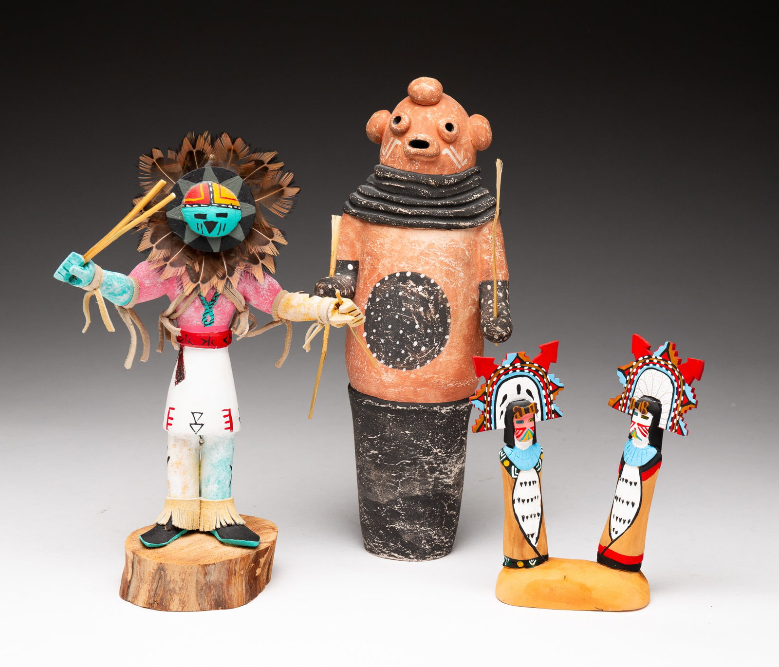 THREE KACHINA DOLLS.: Late-20th or early-21st Century. The first a Sun Face of polychrome painted cottonwood, signed "G Joe "Sun" Face." 8.25"h. The second Shalako Mana and Shaliko Taka of polychrome painted cottonwood, si
