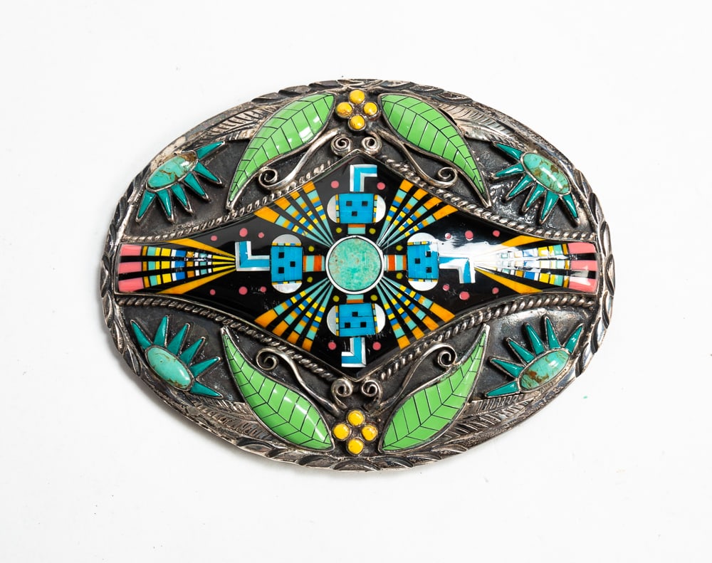 SIGNED INLAID STERLING SILVER BELT BUCKLE.: Mid- to late-20th Century. Oval shape with scroll and feather silverwork, enameled leaves, inlaid berries and suns, the polychrome center an intricate geometric design inlaid with micro stones of mult