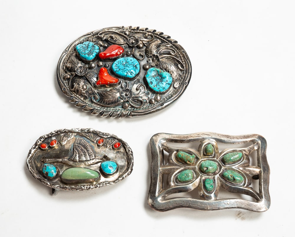 THREE SILVER BELT BUCKLES.: Mid- to late-20th Century. Oval shape with three Kingman turquoise stones and two corals set amid scrolling flowers and feathers silverwork. Marked "T. BAHE" (Tom Bahe) on back with maker's mark. 4"w.