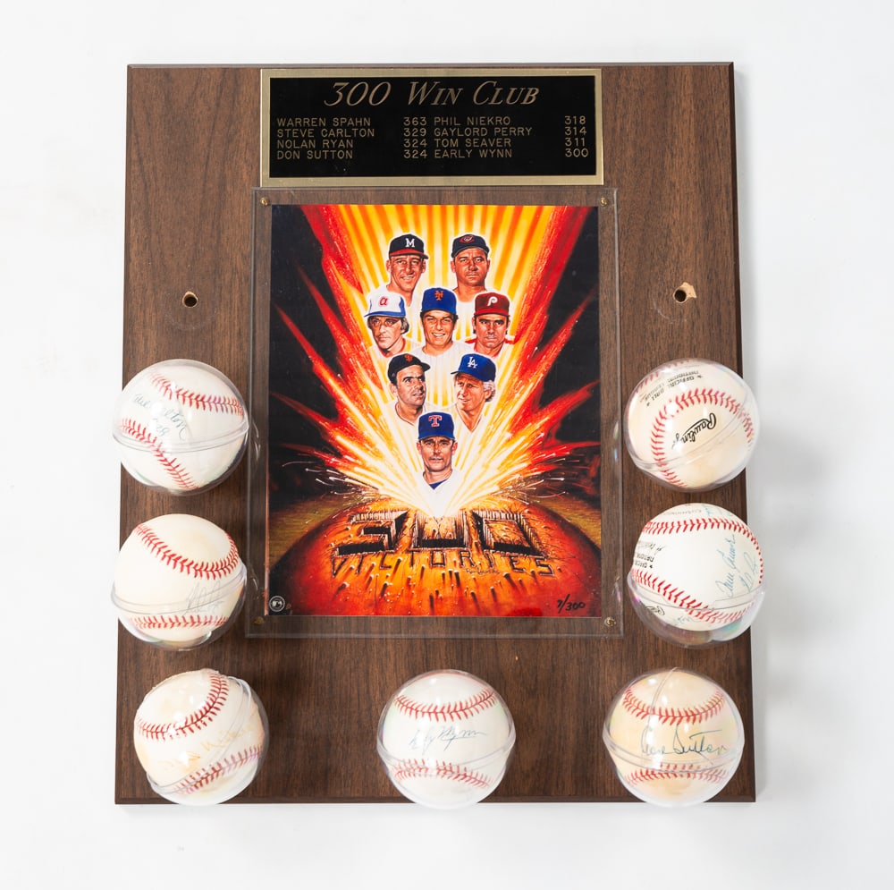 300 WIN CLUB AUTOGRAPHED BASEBALL PLAQUE.: American, fourth quarter 20th Century. Wall plaque with 300 win club engraved tablet. Also holds seven autographed baseballs from the players. Including Steve Carlton, Nolan Ryan, Phil Niero, Don Sutt