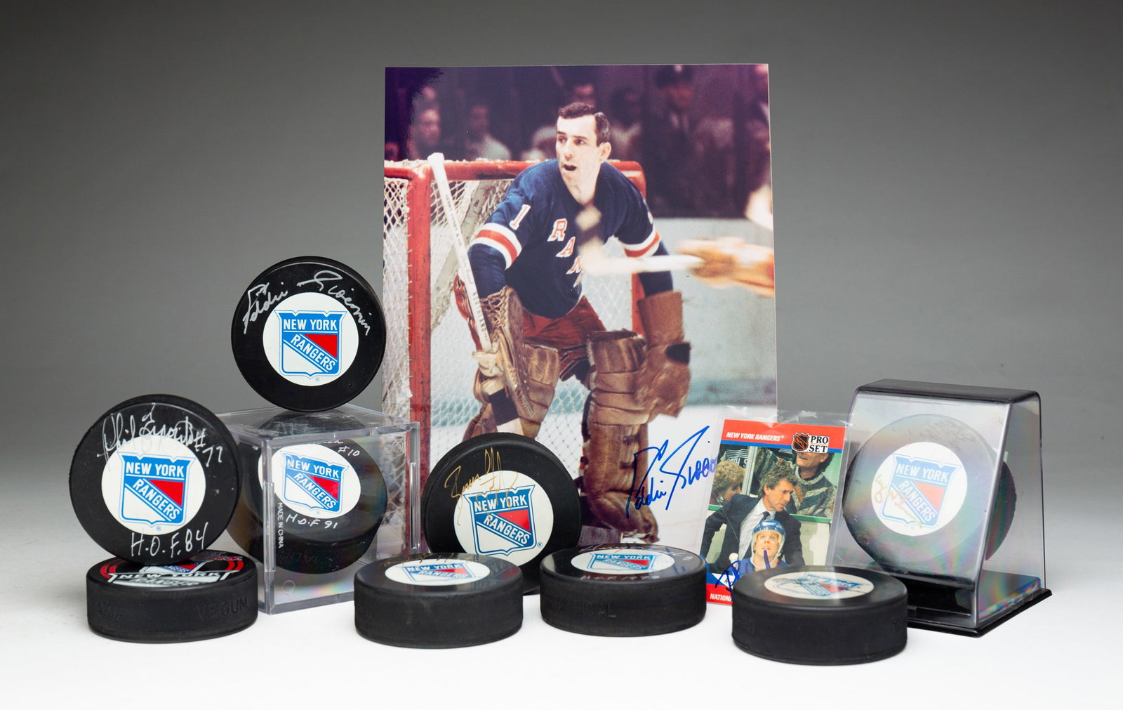 ELEVEN PIECES NEW YORK RANGERS AUTOGRAPHED HOCKEY MEMORABILIA.: American, 20th Century. Nine pucks including Phil Esposito, Harry Howell, Eddie Ciacomi, Clint Smith and five others (one not autographed). Autographed Roger Neilson trading card. Autographed photo of