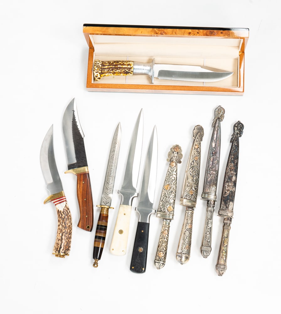 TEN FIXED BLADE KNIVES.: 20th Century. A cased Mossy Oak bowie knife. 10"l. Two Inox Gaucho daggers; an Aragon Mexican dagger; two daggers, one with bone handle and one with ebony handle; two daggers with silver sheaths and c