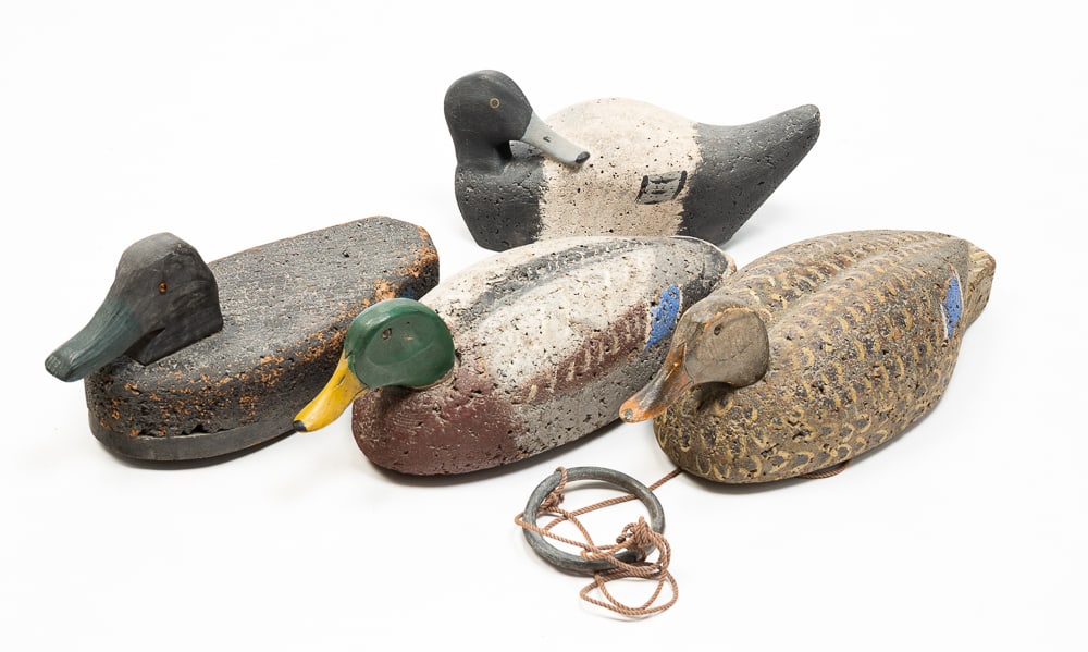FOUR CARVED WOOD AND CORK DUCK DECOYS.: American, early- to mid-20th Century. All unsigned. All with some hardware. Largest 6.25"h. 18"l.