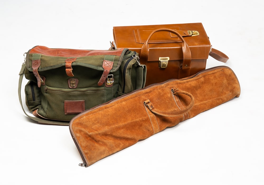 THREE CARRYING CASES.: American, 20th Century. "Monteroy" leather camera case, an Orvis canvas and leather bag and a suede leather long gun soft case.