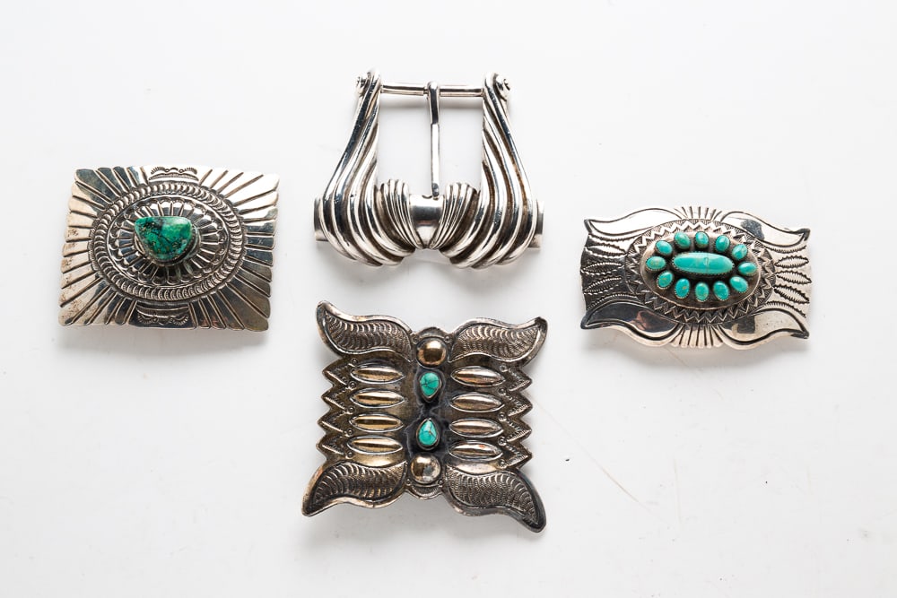 FOUR SIGNED SILVER STERLING BELT BUCKLES.: Mid to Late 20th Century. Waterbug design with two bezel-set teardrop turquoise stones stamped "STERLING TC" (possibly Toni Curtis) on back. 3.5"w. Buckle with curving ridges marked "RON JAY STERLING"