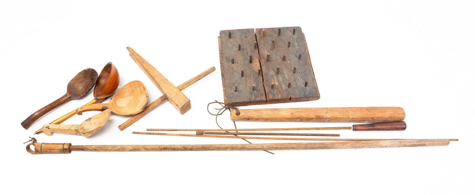 GROUP OF WOODENWARE.: American, 19th Century. Includes scoops, spoon, strainer, rope bed key, ram rods, barrel cleaner , square peg board and a flax club.