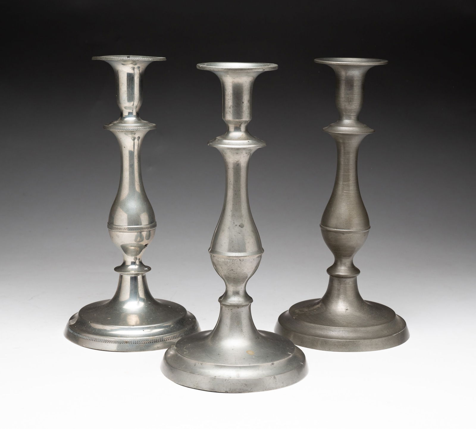 THREE PEWTER CANDLESTICKS. (1 of 4)