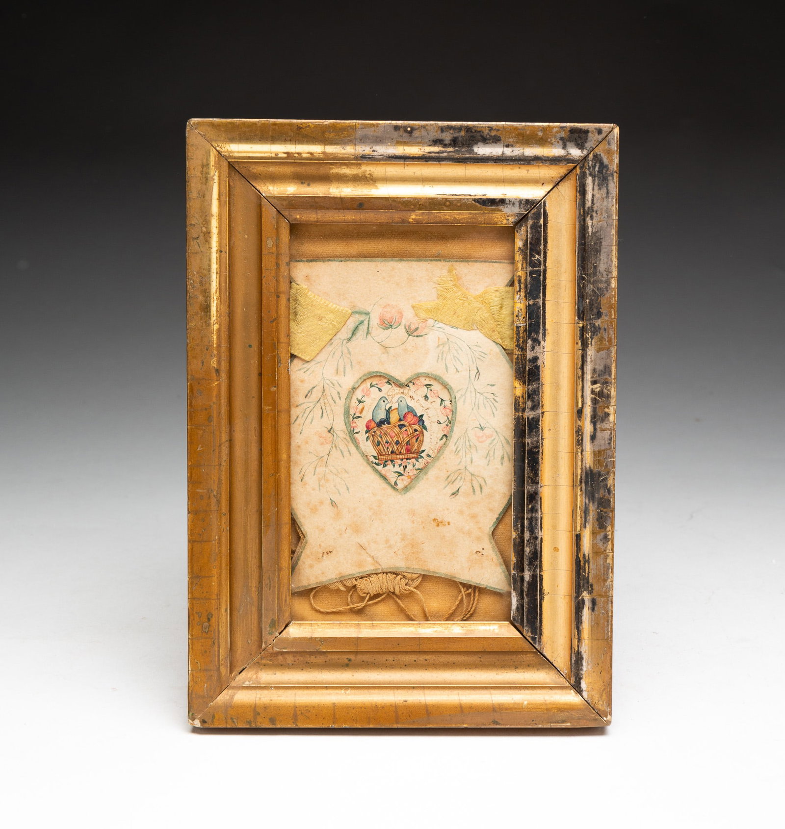 FOLK ART LOVE TOKEN.: FOLK ART LOVE TOKEN. American, circa 1840. Finely detailed watercolor of two doves perched in a basket of fruit within a heart. In gilt frame. 8.5"h. 6"w. From the collection of Carol Schulman (Cheste