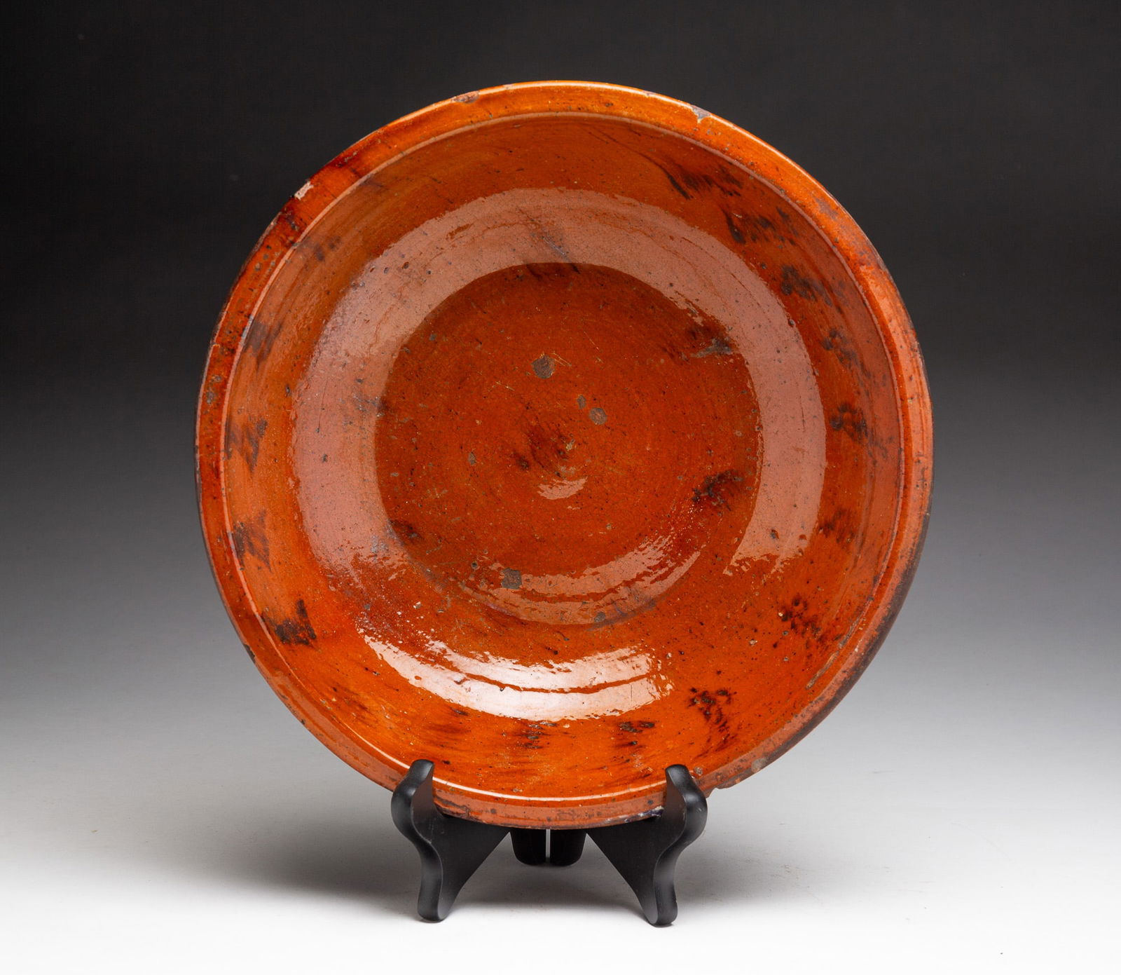 REDWARE BOWL.: REDWARE BOWL. American, 19th Century. Sloped sides with rolled lip, high glaze interior with mottled decoration. 2.75"h. 11.5"d. From the collection of Carol Schulman (Chesterland, Ohio).