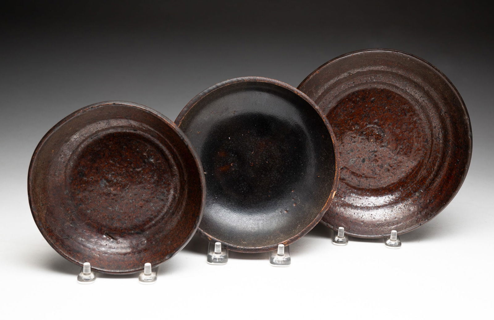 THREE REDWARE SHALLOW BOWLS.: THREE REDWARE SHALLOW BOWLS. American, 19th Century. One with molded under edge. Pennsylvania yellow slip decorated bowl. 9.5"d. Two dark glaze redware bowls, 1.25"h. 7"d. and 1.5"h. 5.5" d. From the