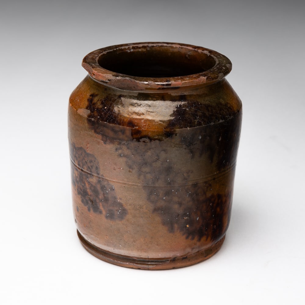 REDWARE JAR.: REDWARE JAR. American, 19th Century. Cylindrical shape, curved shoulder and flared lip. Greenish-brown glaze with dark brown mottling. 4.75"h.