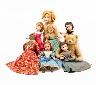 SEVEN DOLLS AND A TEDDY BEAR.