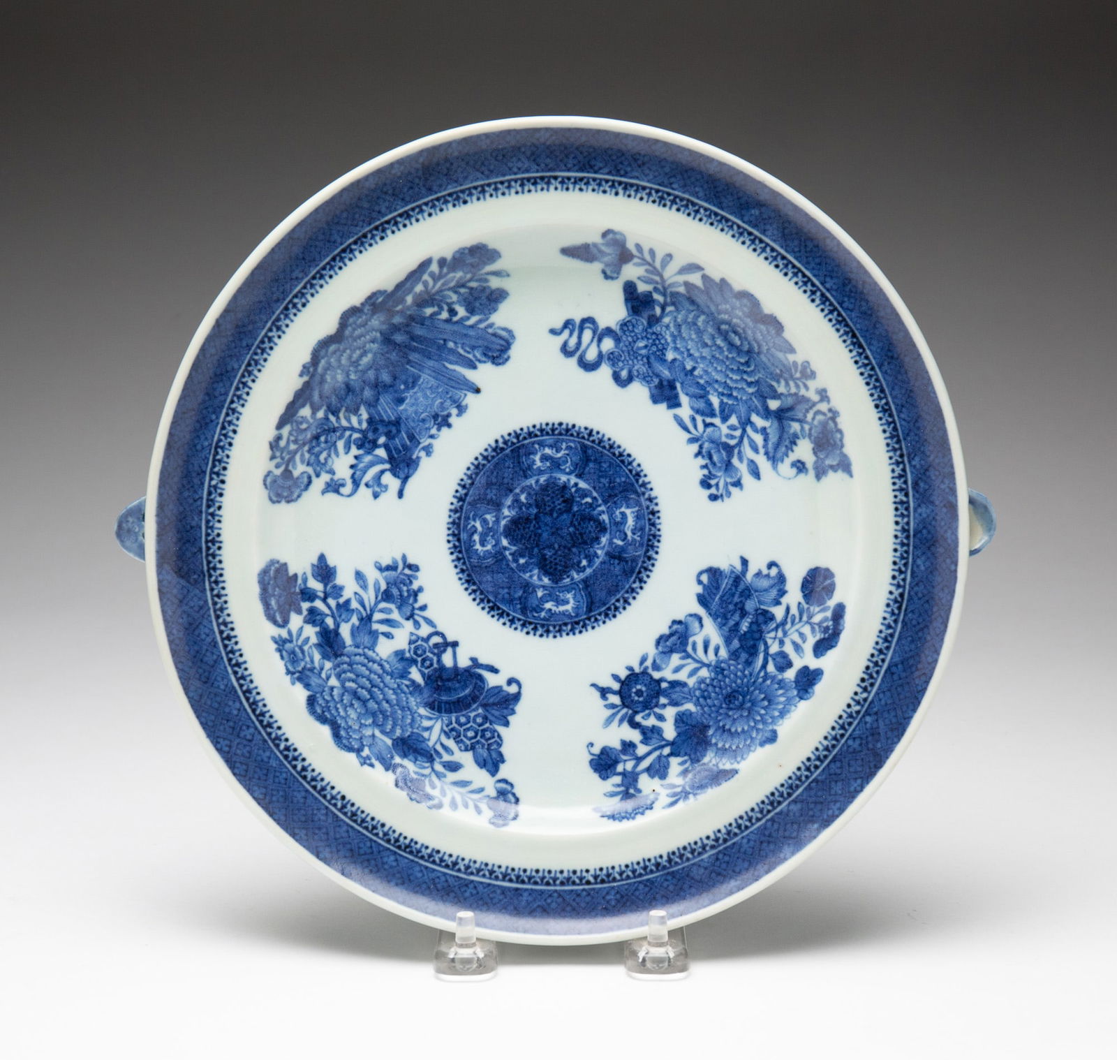 BLUE AND WHITE FITZHUGH PORCELAIN WARMING DISH.: China, circa 1800. Round plate with two water spouts on either side, decorated with central medallion and four chrysanthemum designs, with diaper border. 10.5"w.