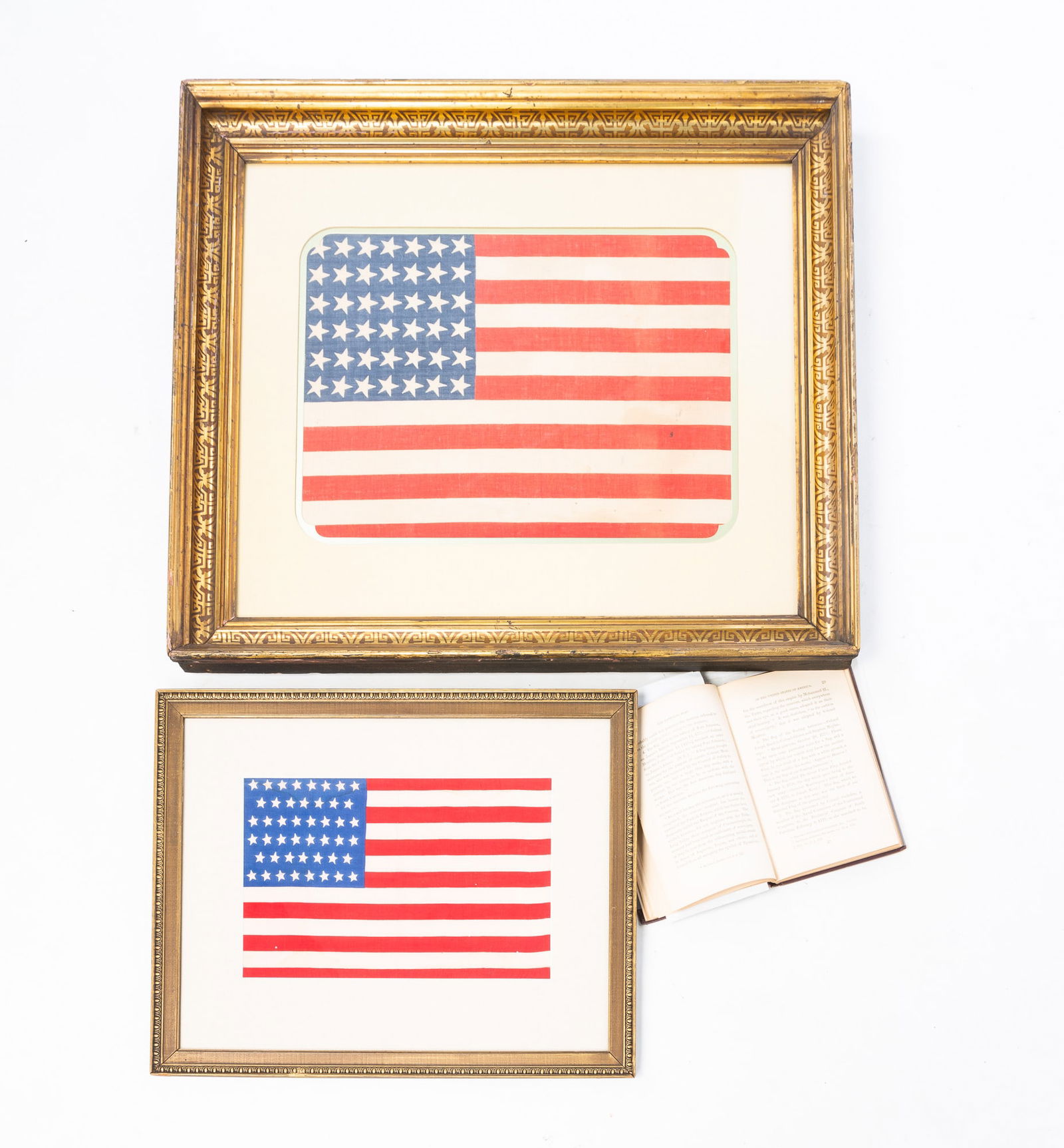 FRAMED 42 STAR AND 46 STAR AMERICAN FLAGS AND A BOOK ABOUT AMERICAN FLAG HISTORY.: American, 19th/20th Century. 42 star American flag, matted and framed under glass. 21.25"h. 24"w. 46 star American flag, matted and framed under glass. 13.75"h. 17"w. Book titled "History of the Natio