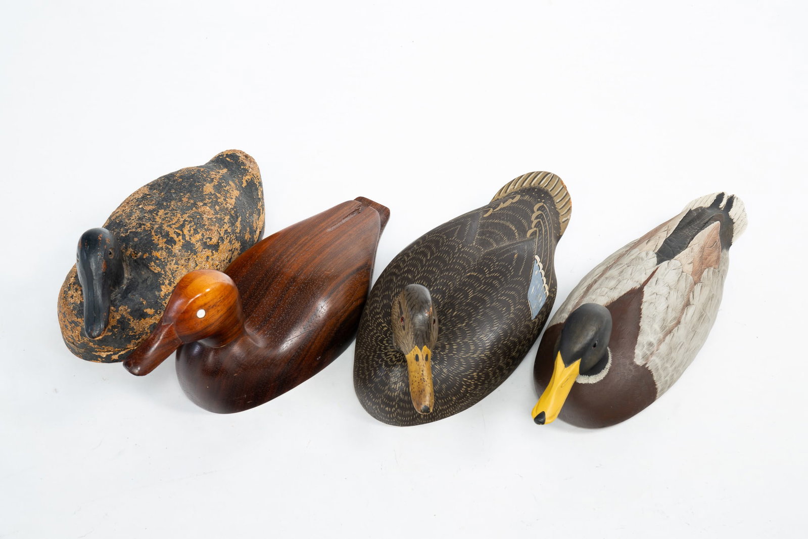 FOUR CARVED WOOD DUCK DECOYS.: American, 20th Century. Carved and painted wood and cork decoy, possibly by Walter Ruppel; carved and painted wood mallard decoy, signed "BOHON 85" on underside; carved and finished wood Padoux mallar