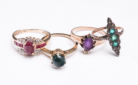 FOUR YELLOW GOLD GEMSTONE RINGS.
