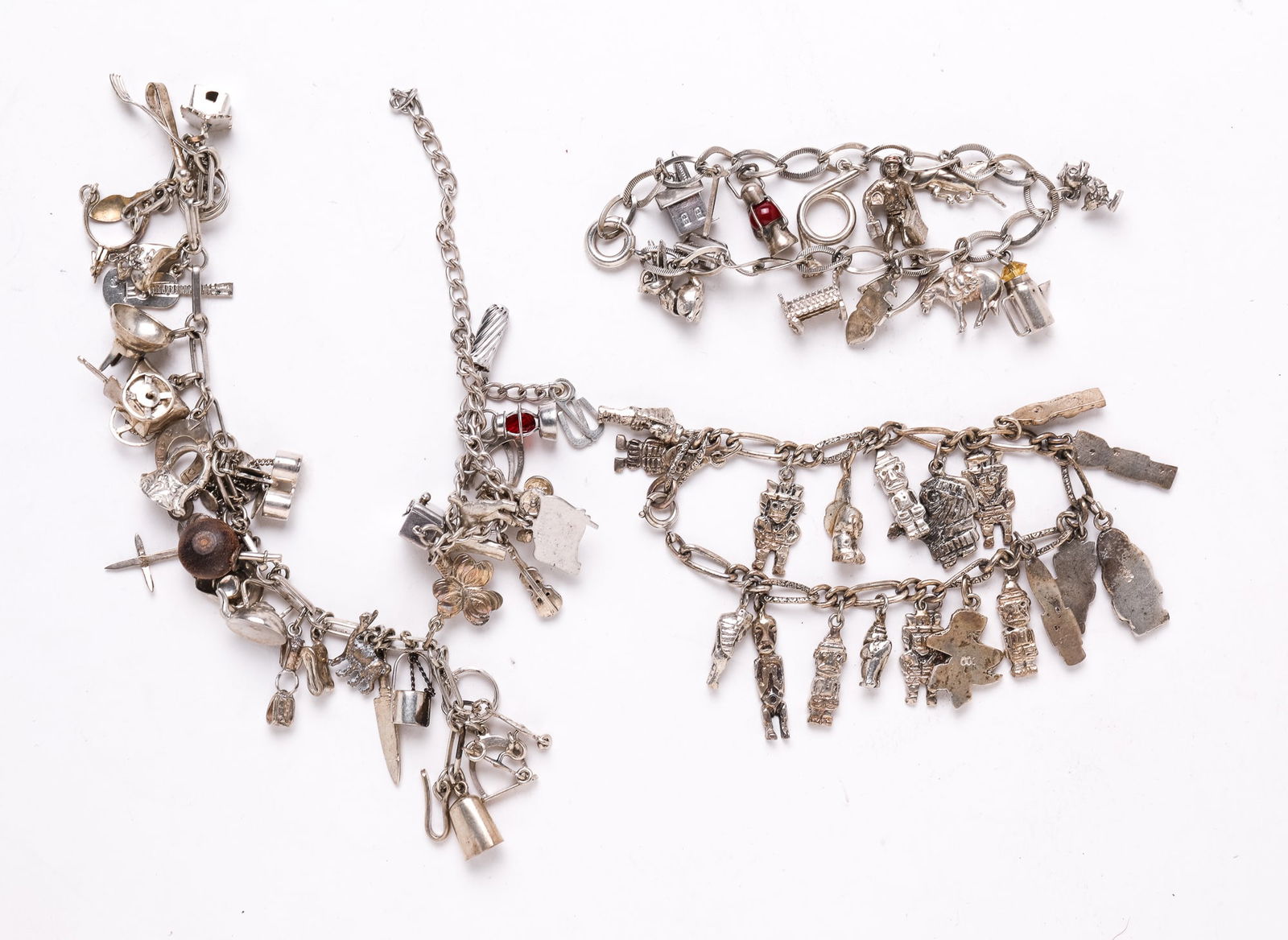 FOUR SILVER CHARM BRACELETS. (1 of 3)