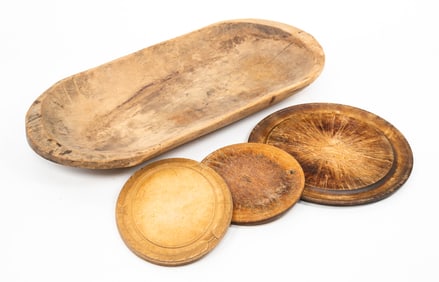 FOUR WOODEN KITCHEN OBJECTS: A TRENCHER AND THREE TURNED PLATES.
