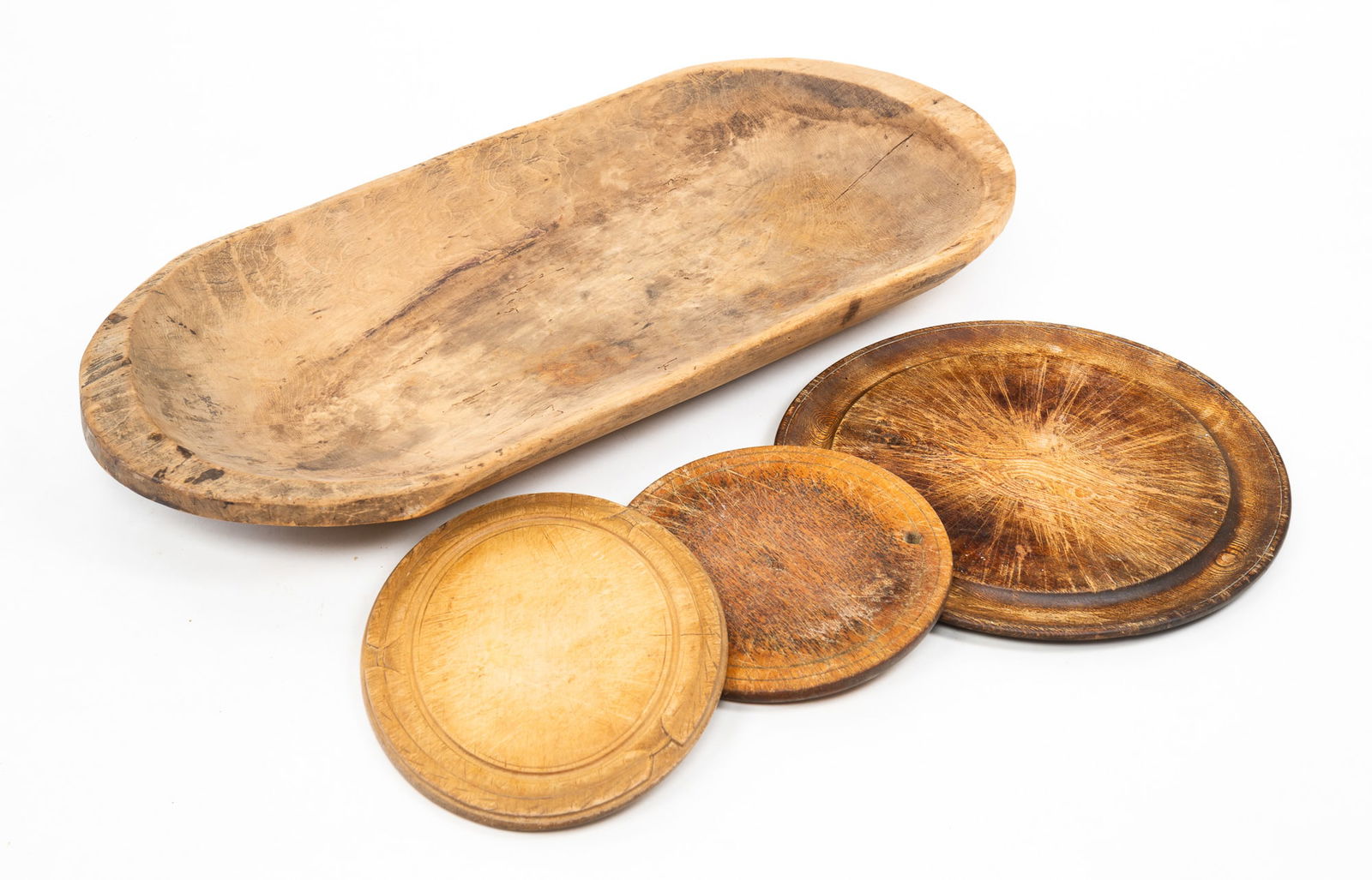 FOUR WOODEN KITCHEN OBJECTS: A TRENCHER AND THREE TURNED PLATES. (1 of 4)
