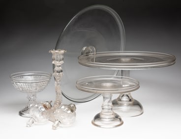COLLECTION OF CLEAR GLASS ITEMS INCLUDING WHALE OIL PEG LAMPS AND CAKE STANDS.