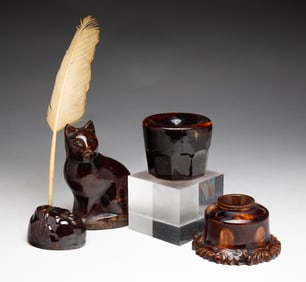 FOUR ROCKINGHAM GLAZED ITEMS: THREE INKWELLS AND A CAT.