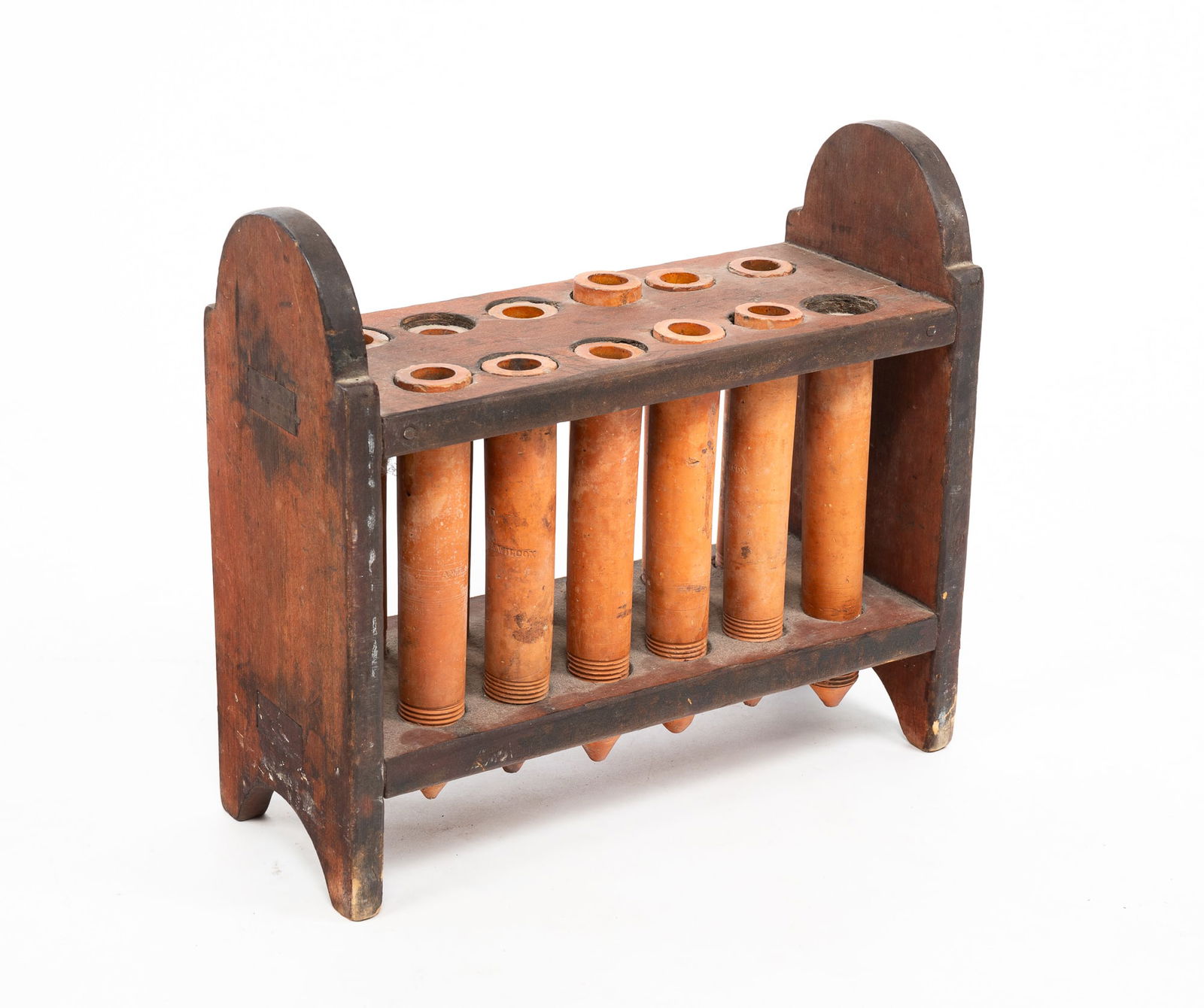 "A. WILCOX" REDWARE CANDLE MOLD.: American (Ontario County, New York), 19th Century. Twelve redware candle tubes impressed "A. Wilcox" threaded into poplar frame with ends having half round cut out feet and tombstone tops. Frame has m