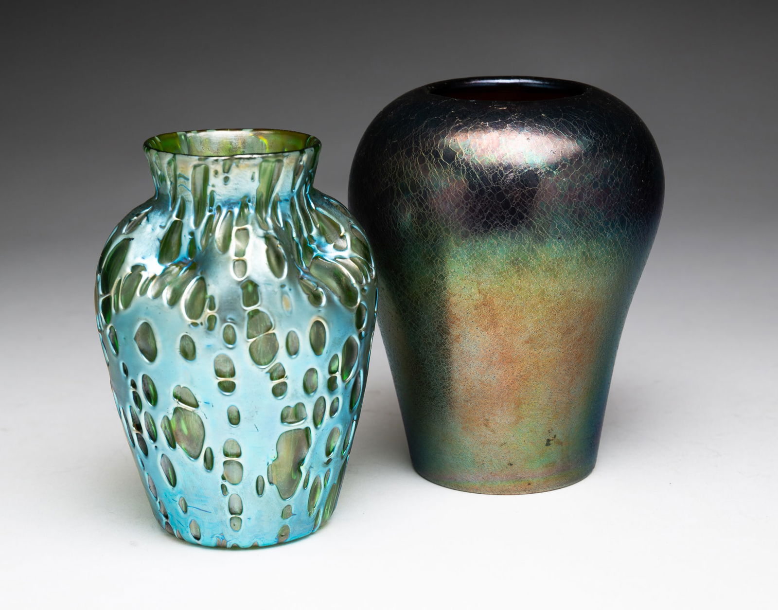 TWO PIECES OF IRIDIZED GLASS.: 20th Century. An American Imperial Glass Company amethyst vase with embossed mark on bottom, 5''h. And an European Loetz style green vase, 4.75"h.
