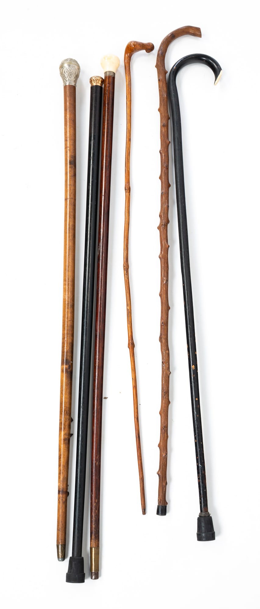 GROUP OF SIX FOLK ART CANES OR WALKING STICKS.: American, 20th Century. A black painted cane with name inscribed on crook handle, a cane with a round bone top, a cane with a decorated silver top, and a black painted cane with a decorated brass top,