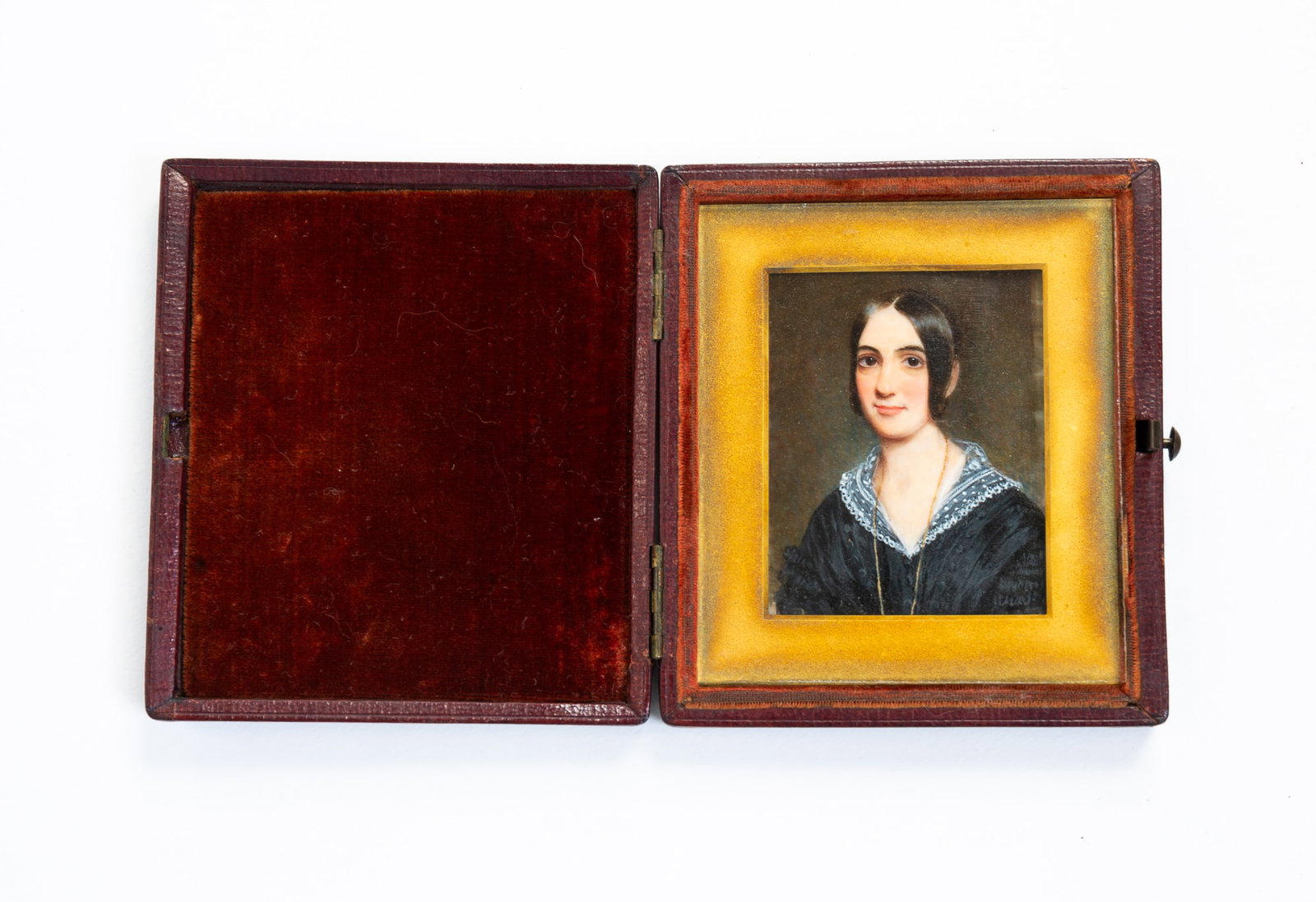 CASED MINIATURE PORTRAIT OF A BEAUTIFUL YOUNG LADY.: European, 19th Century. Woman with dark hair wearing a black dress with lace collar and a gold necklace. Encased with brass frame and glass. 4"h. 3.75"w. From the lifetime collection of the late Audre