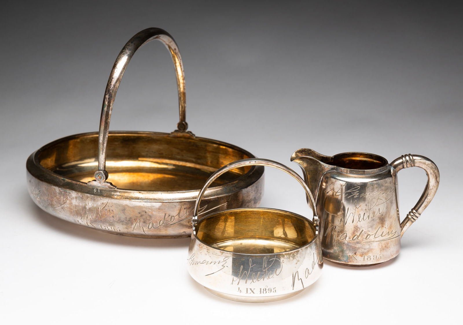 THREE PIECES OF GRACHEV BROTHERS STERLING SILVER.: Russia (St. Petersburg), 19th Century. All three have 1895 assayers marks, engraved date of September 4, 1895 and have three names engraved on each piece. All three also have vermeil interiors. Creame