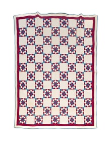 PIECED QUILT IN AN EIGHT POINTED STAR PATTERN.