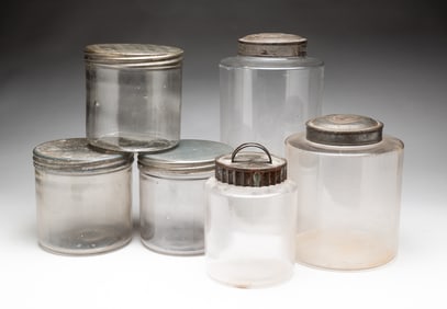 SIX MOLDED GLASS CANISTERS WITH TIN LIDS.