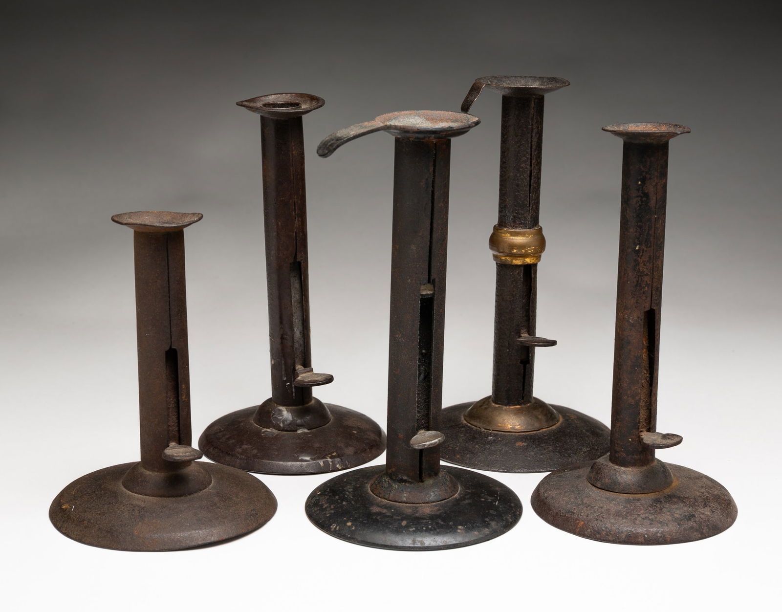 FIVE TIN HOGSCRAPER CANDLESTICKS. (1 of 4)