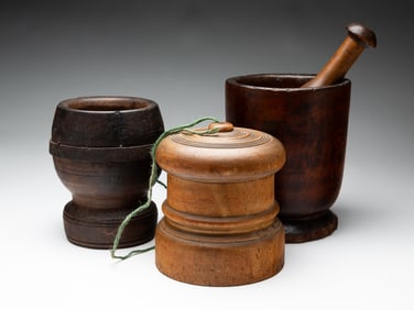 TWO TREEN MORTARS, A PESTLE, AND A STRING HOLDER.