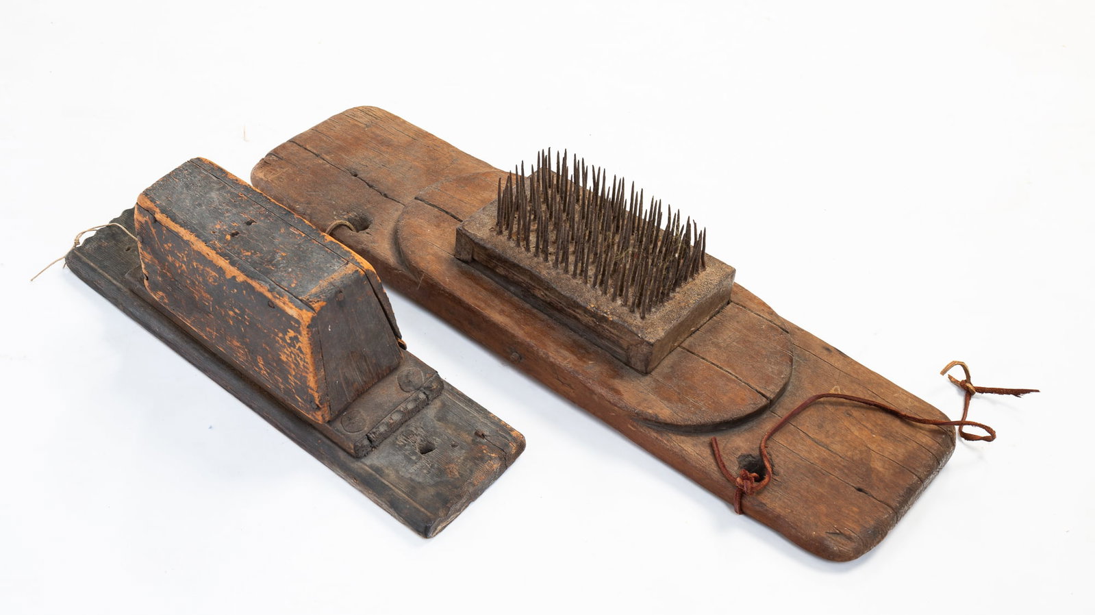 TWO FLAX HETCHELS.: American, 19th Century. Iron spikes on wood boards. The larger hetchel constructed square cut nails and several carved initials, one on back reading "WBH 1864." 5"h. 24"w. 6.5"d. The smaller construct