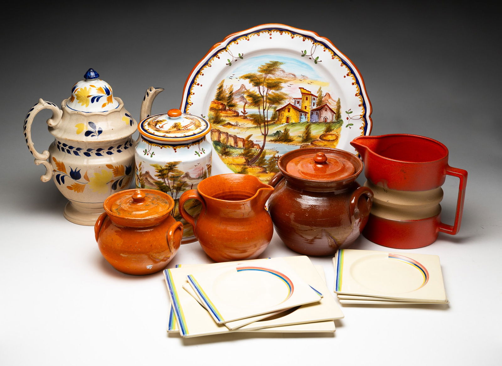 GROUPING OF REDWARE, FAIENCE AND CHINA.: American and European, late 19th and early 20th Centuries. Seven Royal Staffordshire "Bizarre" by Claria Cliff plates, an earthenware tall pot with floral decoration, 12"h., a Grazia Deruta platter an