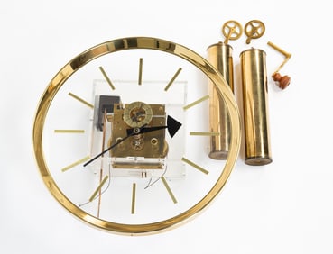 HOWARD MILLER LUCITE AND BRASS WALL CLOCK.