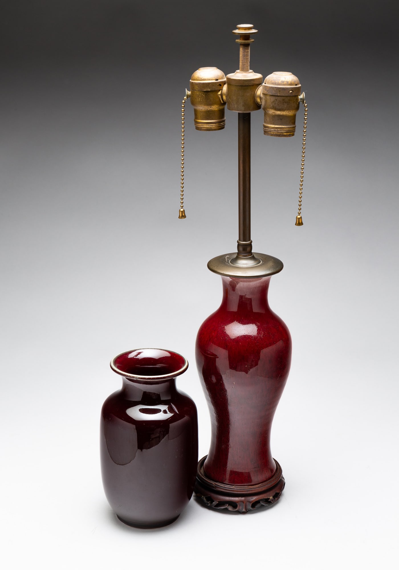 TWO CHINESE SONG DE BOEUF VASES.: China, circa 1900. A squat vase with flared rim and dark rich color, 7.25"h. And a slender vase with bulbous body and flared lip. Has been drilled for use as a lamp. Vase, 9.75''h. Overall, 20.5"h.