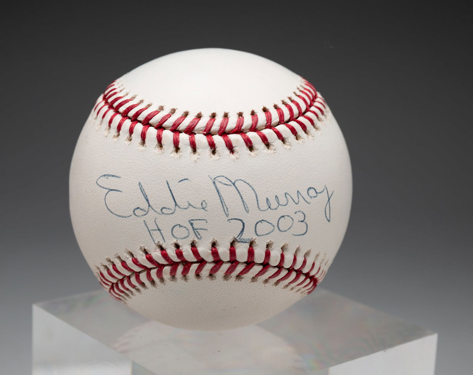 AUTOGRAPHED BASEBALL BY EDDIE MURRAY.: American, 21st Century. OML Selig baseball in square plastic display with Saks Fifth Avenue registration (?) label. Signed and inscribed, "HOF 2003". Murray played for the Baltimore Orioles, Los Angel