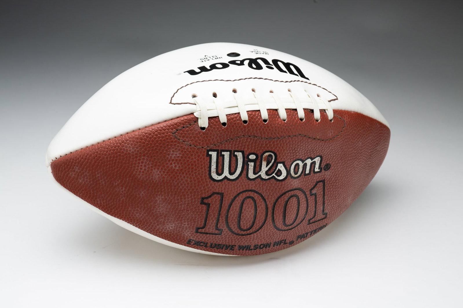 AUTOGRAPHED OHIO STATE FOOTBALL BY EDDIE GEORGE, TERRY GLENN AND BOBBY HOYING.: American, 20th - 21st Century. Two-tone Wilson 1001 Ohio State logo'd football. Faded signatures. George, Glenn, and Hoying all played for the Ohio State Buckeyes.