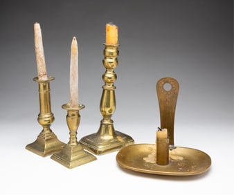 THREE BRASS CANDLESTICKS AND A BRASS WALL SCONCE.