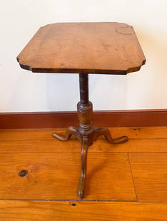 LATE QUEEN ANNE FIGURED MAPLE CANDLESTAND.: American, late 18th Century. Tiger maple. Rectangular top with shaped corners, turned column with vase shaped base, snake legs, and pad feet. 26"h. 17''w. 15.25''d.