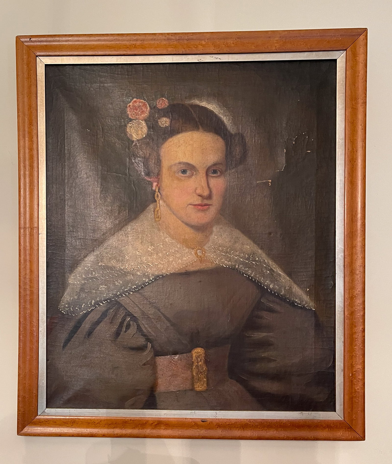 AMERICAN SCHOOL PORTRAIT OF A WOMAN.: American, 19th Century. Oil on canvas. Unsigned. A bejeweled seated woman with her hair in an updo with flowers, wearing a lace collar, dress with puffy sleeves and a large belt. 24"h. 20.25"w. In a w