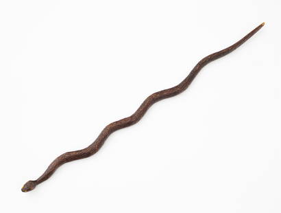 FOLK ART CARVED WOOD SNAKE.: American, circa 1900. Carved wood. Typical snake form with yellow bead eyes. 36"l.