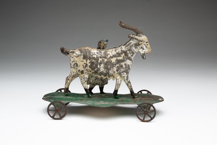 PRESSED TIN AND PAINTED GOAT AND CHILD PULL TOY.