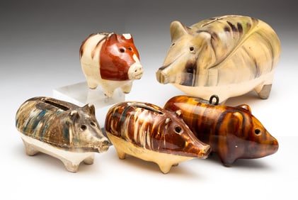 FIVE MOTTLED GLAZED EARTHENWARE PIGGY BANKS.