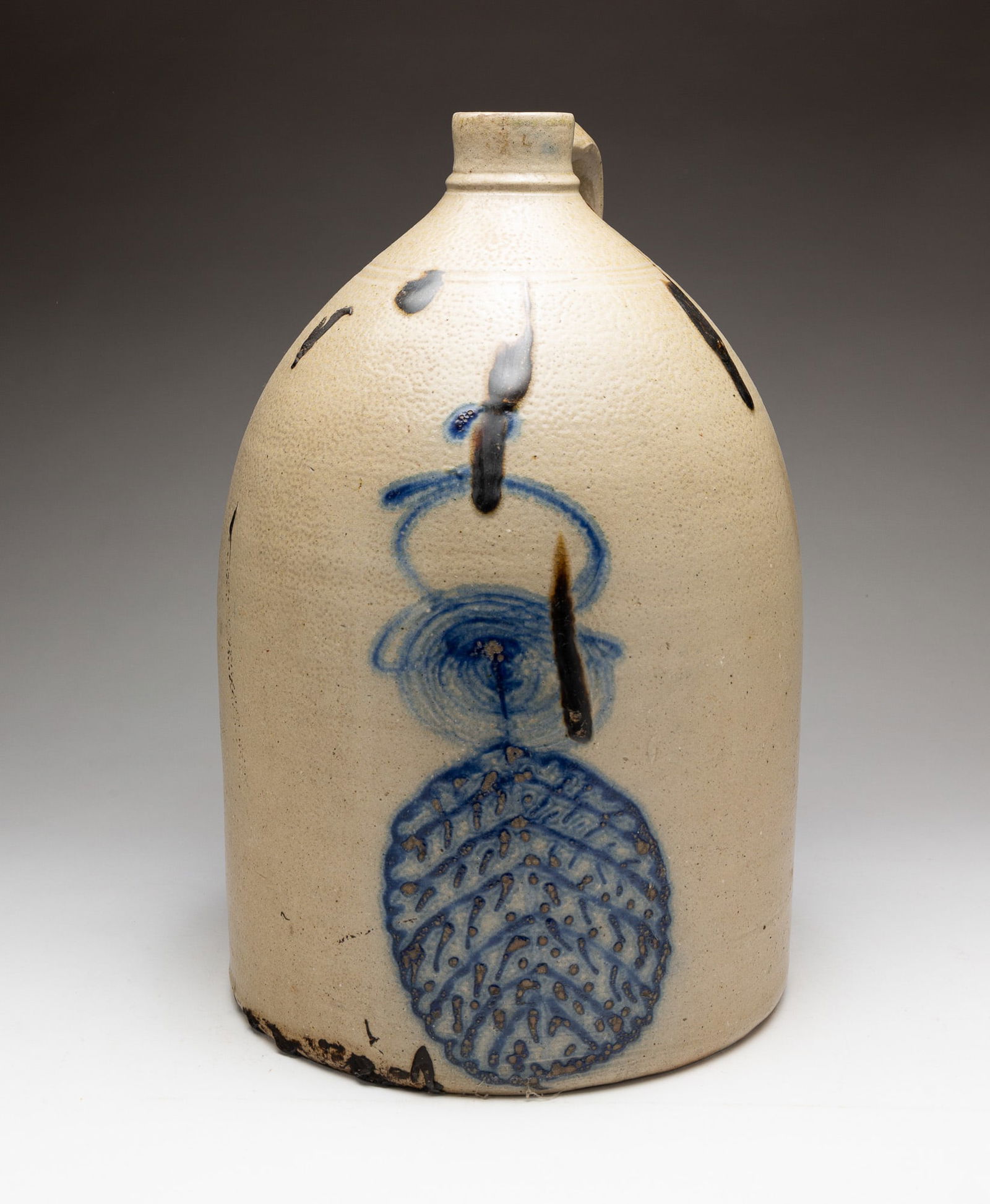 STONEWARE JUG WITH COBALT DECORATION.: American, 19th Century. Applied handle, cobalt leaf and bee stinger decoration with some dark brown splotches. 15''h.