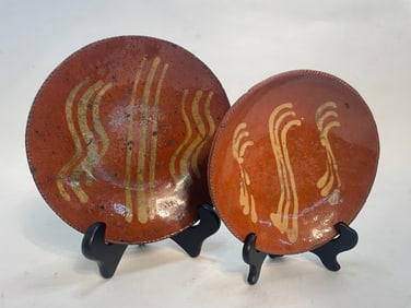 TWO SLIP DECORATED REDWARE PLATES.